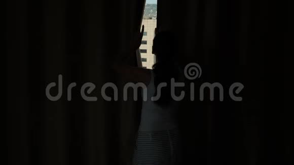 女人在窗外拉开窗帘看看巴塞罗那市中心的全景视频的预览图
