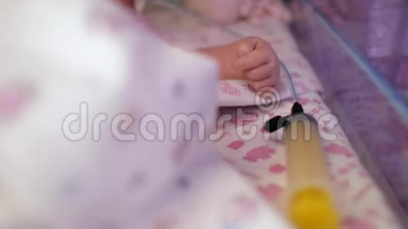 新生儿的特写在一个专门的盒子里放在一个注射器旁边儿童特护病房4k4kvid视频的预览图