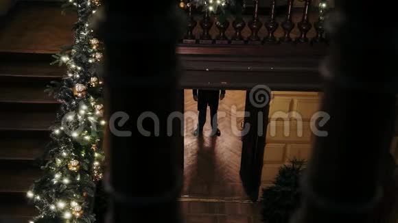 一个男人走进装饰着圣诞装饰的房间视频的预览图