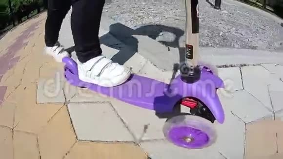 一个小孩在铺板上骑着滑板车的腿视频的预览图