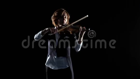 女孩用手指弹奏小提琴的琴弦黑色背景视频的预览图