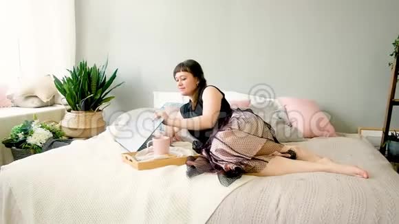 女人躺在床上用笔记本电脑工作自由职业者在家工作视频的预览图