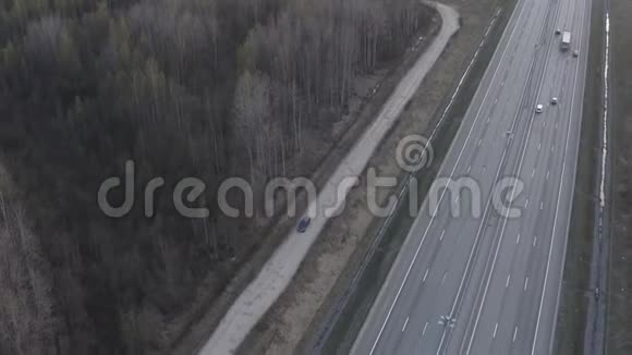 一辆汽车沿着土路沿着高速公路行驶视频的预览图