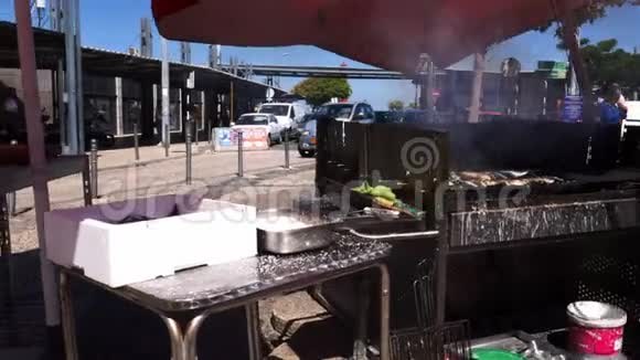 在葡萄牙的露天咖啡馆里新鲜的沙丁鱼在热腾腾的烧烤上烹饪视频的预览图