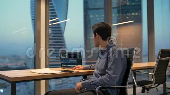西班牙裔雇员男性商务办公室坐在扶手椅上手提电脑视频的预览图