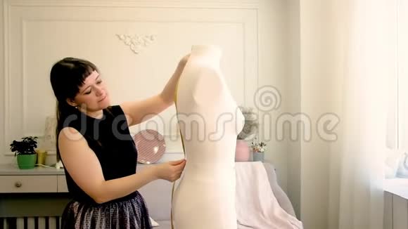 裁缝师专业时装设计师测量一个有米的人体模型视频的预览图