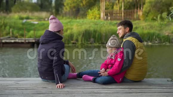 秋日一家人坐在码头上视频的预览图