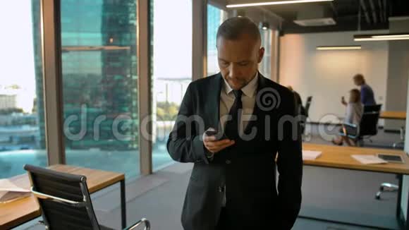 一位英俊男子站在阁楼房间的窗户附近写短信的画像视频的预览图