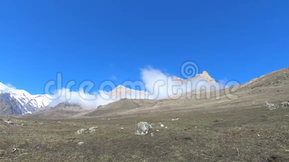 白天时间在北高加索山区以一个广阔的角度流逝在史诗岩石脚下旋转的云视频的预览图