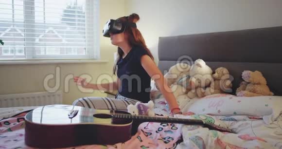 穿着睡衣的少女在卧室里探索一种虚拟现实眼镜的新发明她视频的预览图