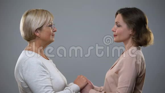 成熟的母亲和成年的女儿双手相视亲密无间视频的预览图