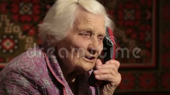 老年妇女在电话上讲话用旋转拨号视频的预览图