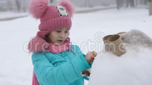 小女孩装饰雪人冬季运动会视频的预览图