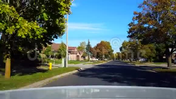 后景从汽车驾驶的背面绕道弯曲在住宅郊区的日子车辆转弯后的车景点视频的预览图