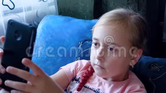 少女坐在床上玩电话视频的预览图