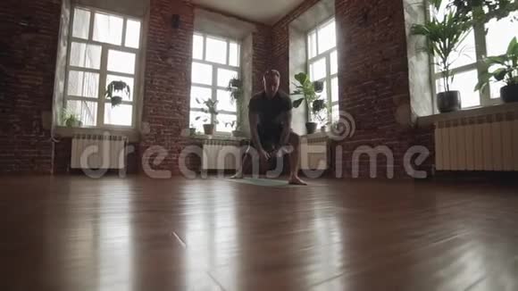 男子练习战士瑜伽姿势在工作室与砖墙做瑜伽的运动男视频的预览图