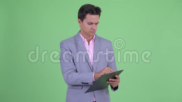 快乐年轻英俊的商人拿着剪贴板指挥视频的预览图