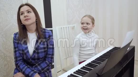小可爱的女孩检查耳朵听她的老师的音乐视频的预览图