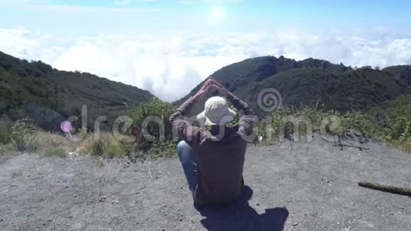 人到达山顶他坐着放松从云层上方欣赏风景令人自豪的是视频的预览图