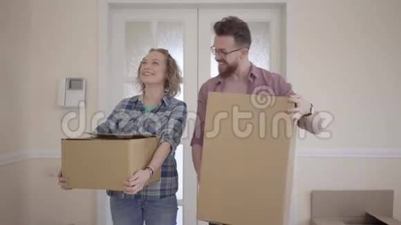 快乐的男人和女人穿着休闲装手里拿着盒子站在房间里近距离地环顾四周已婚夫妇视频的预览图
