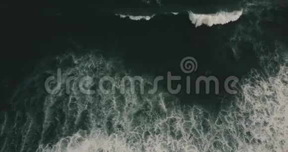 无人机在巨大的深蓝色开阔的海浪上移动白色的海泡形成史诗般的自然纹理视频的预览图