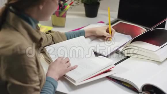 年轻女子写着书读着书脸上带着微笑转身对着镜头视频的预览图