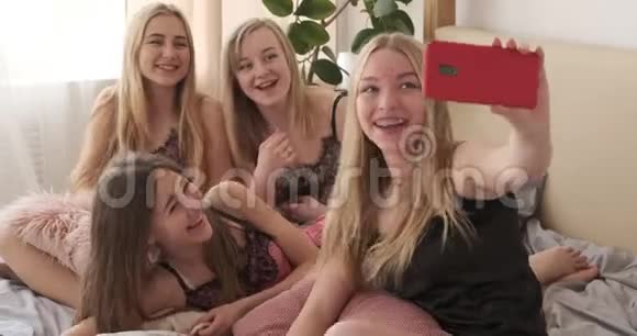 青少年女孩在睡眠聚会上用手机与朋友聊天视频的预览图