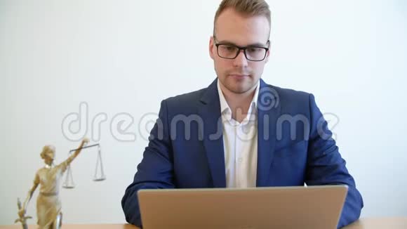 年轻律师在律师办公室桌上的笔记本电脑上打字视频的预览图