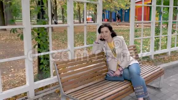 坐在公园长椅上的白人中年黑发女性视频的预览图