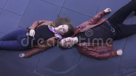 男人和女人一起在深色瓷砖地板上唱歌他们穿着浅棕色的夹克视频的预览图