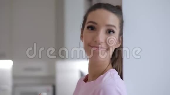 可爱的美丽微笑的女人靠在窗台上拿着雪人饼干的画像视频的预览图