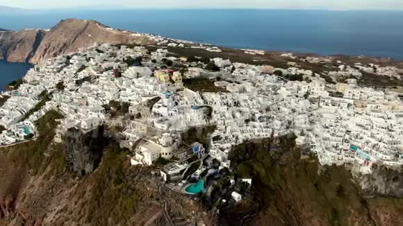 希腊圣托里尼岛日落时分飞越伊梅罗维利村和斯卡罗斯岩飞越白与蓝视频的预览图