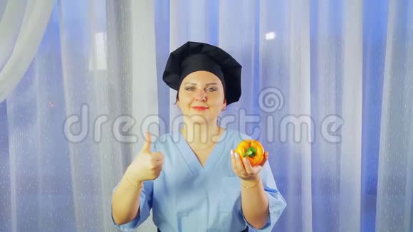 一位女厨师微笑着手里拿着一根黄椒向全班同学展示视频的预览图