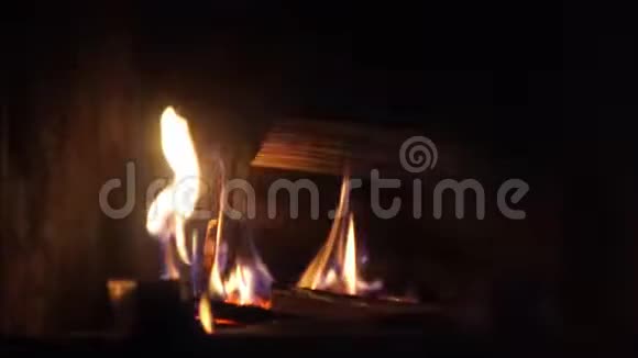 在舒适的砖制壁炉中用橙色火焰缓慢燃烧的木头上拍摄了非常令人满意的特写镜头视频的预览图