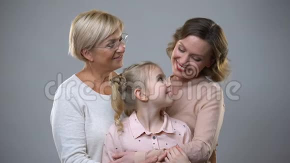 祖母女儿和孙子在灰色背景下拥抱信任关系视频的预览图