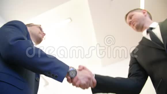两个商人在商务办公室开会时握手背景为白色视频的预览图