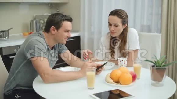 微笑的夫妇一起在豪华厨房吃早餐视频的预览图