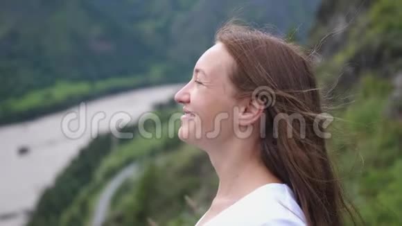 幸福微笑的旅游妇女欣赏山顶的景色慢动作视频的预览图