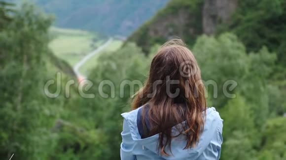 梦中的女孩坐在群山的背景上头发飞扬回头看慢动作视频的预览图