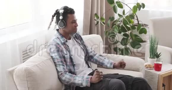 男人在家里通过耳机欣赏音乐视频的预览图