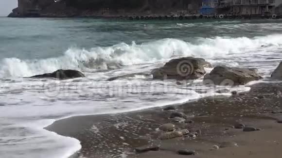 在克里米亚的诺维斯维特村荒凉的沙滩上一小波纯净的黑海在一块石头上流淌视频的预览图
