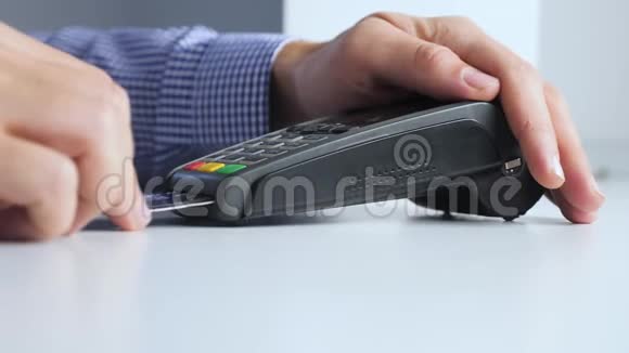用信用卡支付商品和服务的购销店里的信用卡人付钱给读卡器视频的预览图