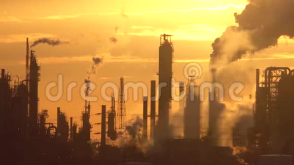 日落时分炼油厂高塔散发着烟雾视频的预览图