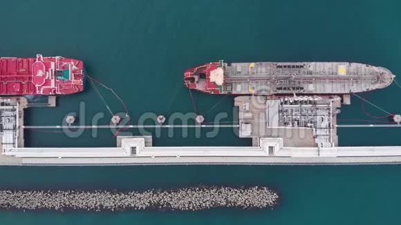 巨大的红灰色油轮停泊在输油码头视频的预览图