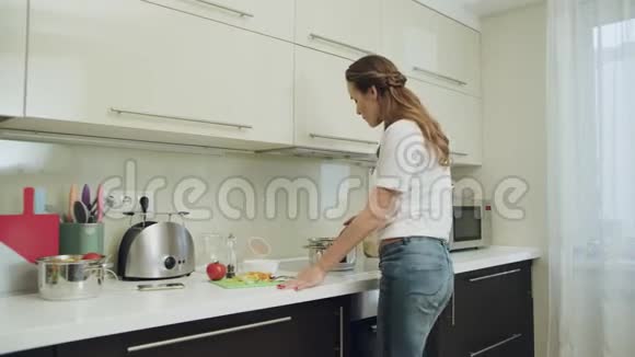 年轻女子独自跳舞很开心女性在家厨房做饭视频的预览图