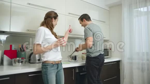 跳舞的夫妇在家做健康的食物时玩得很开心视频的预览图