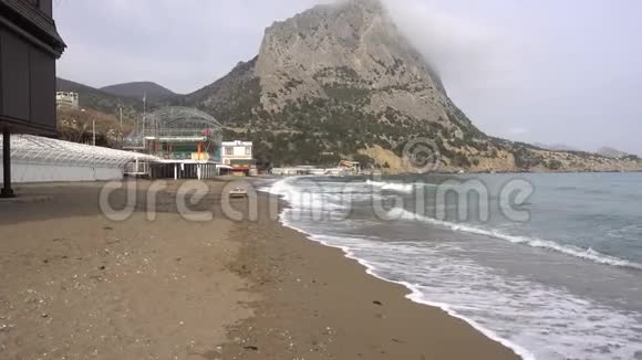海浪在黑海废弃的鹅卵石海岸上流动克里米亚的诺维斯维村阴云密布的春日视频的预览图