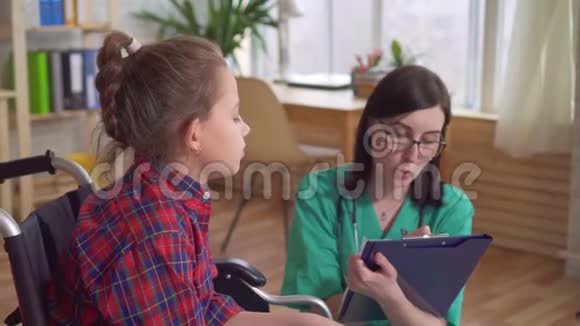 女医生和一个坐轮椅的残疾孩子说话视频的预览图