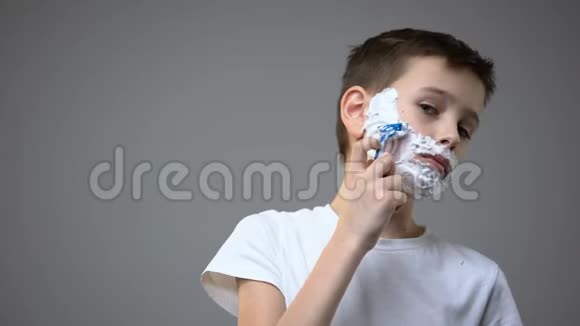 有趣的小男孩刮胡子假装成人模仿父亲的行为视频的预览图