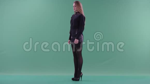 一位身穿黑色便服的年轻美女正对着绿色的屏幕竖起大拇指视频的预览图